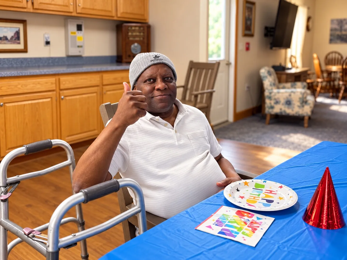 A resident giving a thumbs-up at a birthday party table