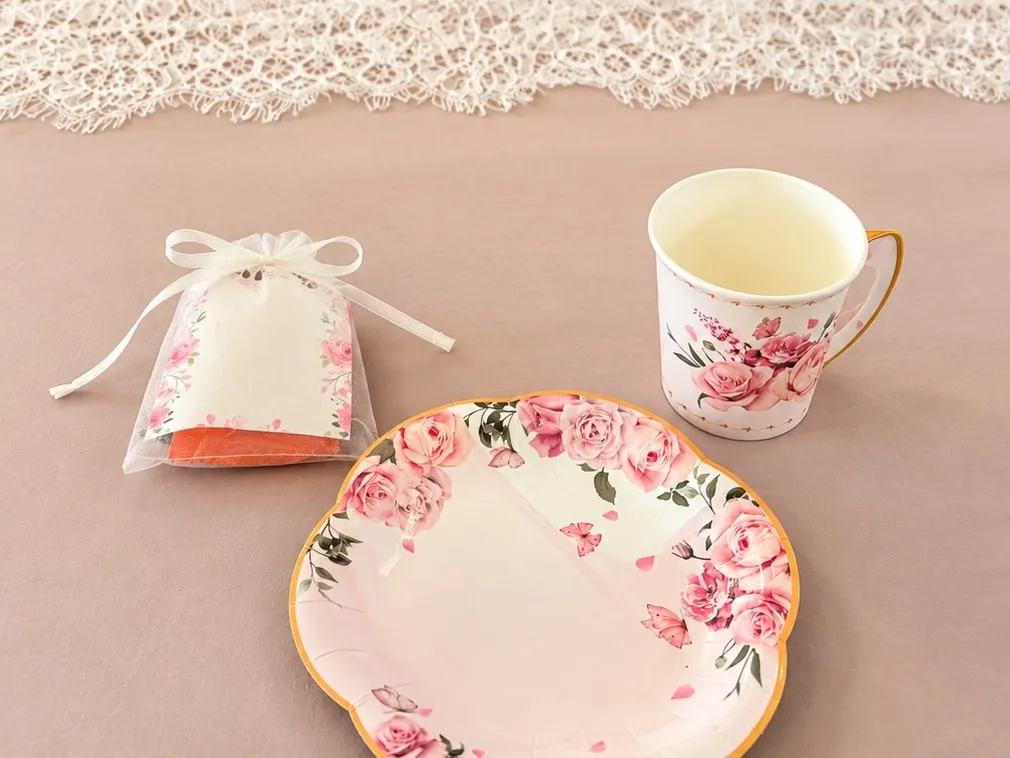 A rose-patterned teacup, plate and party favor set for afternoon tea