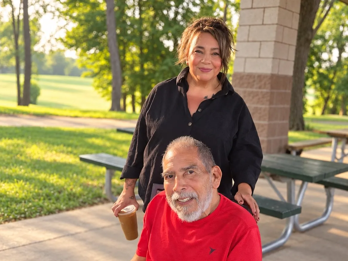 A resident holding a small dog outdoors, with a woman standing behind him