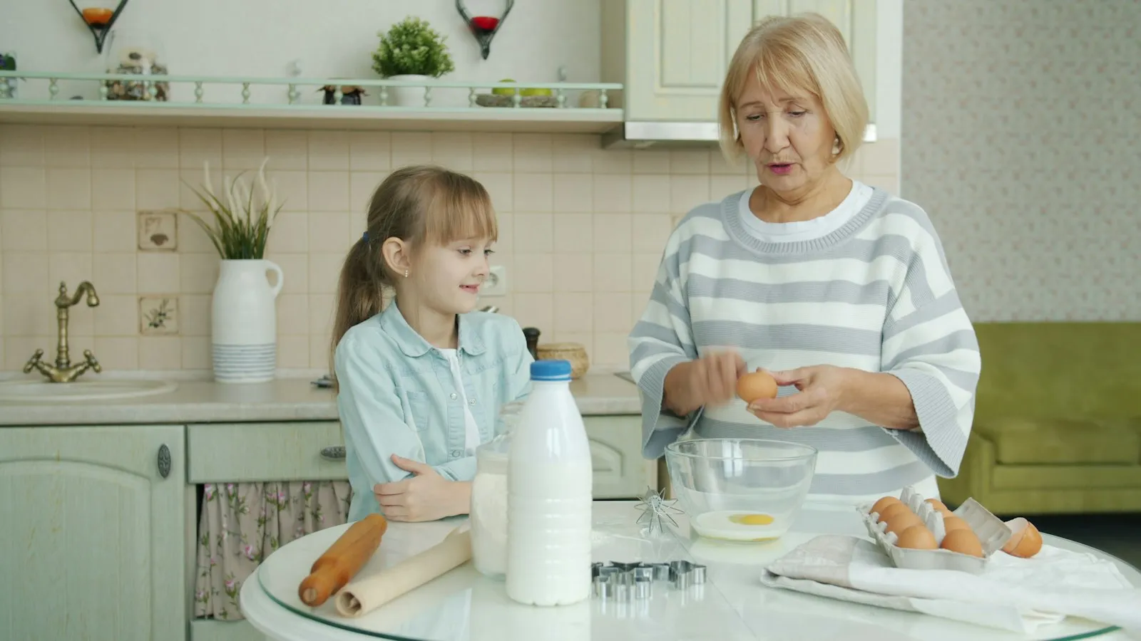 A grandmother baking with her granddaughter in a bright kitchen